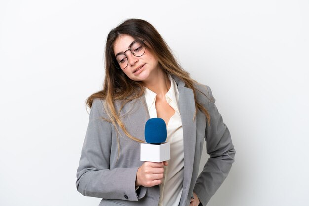 Jovem apresentadora de tv caucasiana isolada em fundo branco sofrendo de dor nas costas por ter feito um esforço