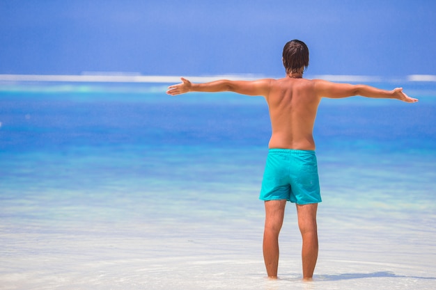 Jovem, aproveitando as férias de verão na praia tropical