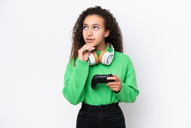 Jovem árabe brincando com um controlador de videogame isolado no fundo branco e olhando para cima