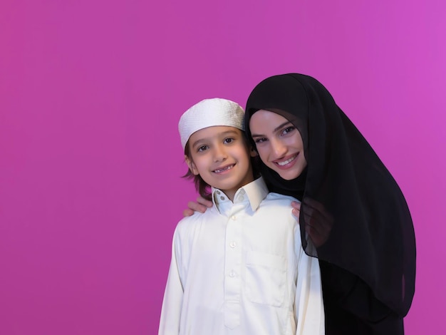 jovem árabe mãe e filho vestindo roupas tradicionais em sua casa moderna, passando algum tempo juntos durante o Ramadã