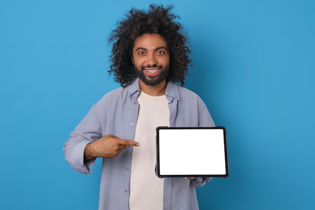 Foto jovem árabe segura um tablet eletrônico e aponta o dedo para a tela verde