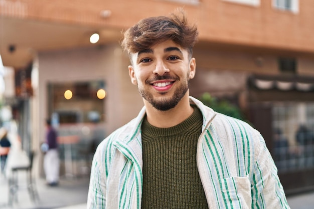 Jovem árabe sorrindo confiante em pé na rua