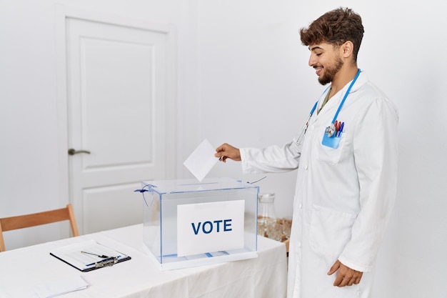 Jovem árabe vestindo uniforme médico votando no colégio eleitoral