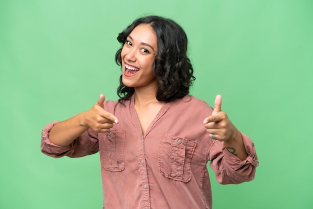 Foto jovem argentina sobre fundo isolado, apontando para a frente e sorrindo