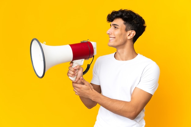 Jovem argentino isolado gritando em um megafone para anunciar algo