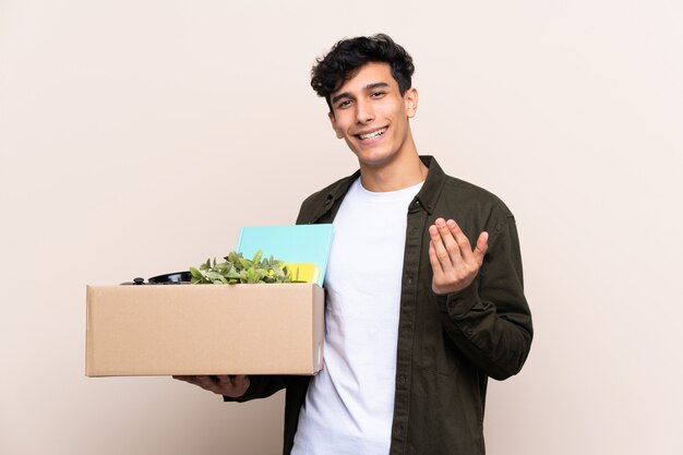 Jovem argentino, movendo-se em nova casa isolado convidando para vir com a mão. Feliz que você veio