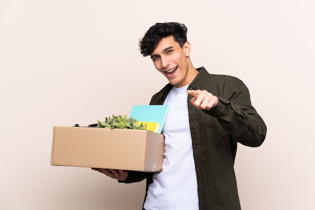 Jovem argentino, movendo-se em nova casa sobre o dedo pontos isolados para você com uma expressão confiante