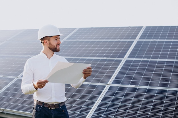 Jovem arquiteto ao lado de painéis solares