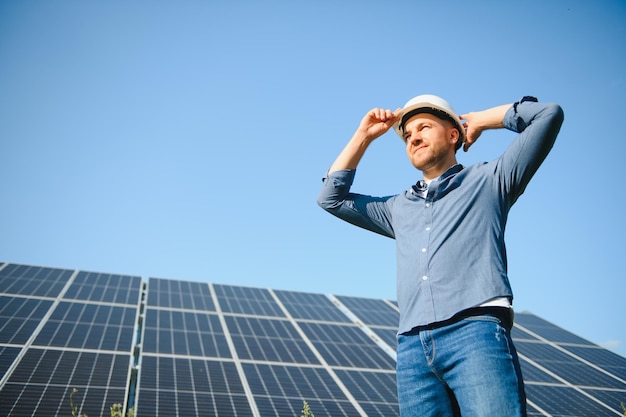 Jovem arquiteto ao lado de painéis solares