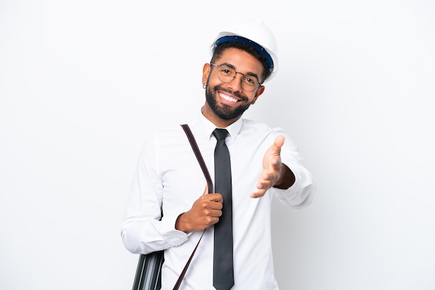 Jovem arquiteto brasileiro com capacete e segurando plantas isoladas em fundo branco apertando as mãos para fechar um bom negócio