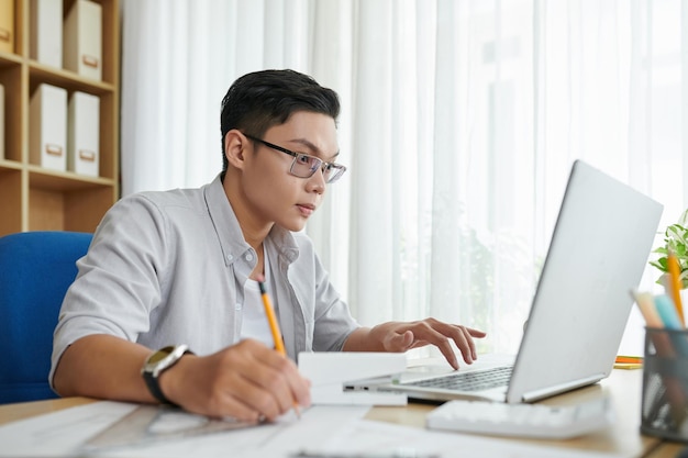 Jovem arquiteto lendo e-mail do cliente