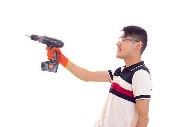 Jovem arrogante em camiseta branca e azul com óculos de proteção, segurando a chave de fenda elétrica