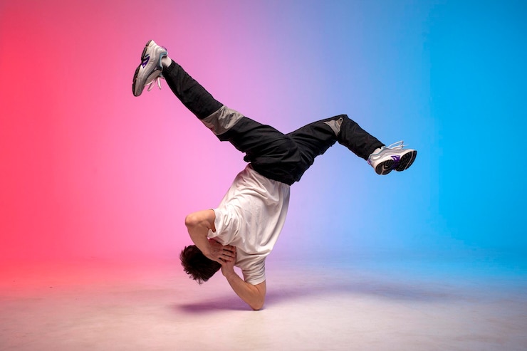Foto jovem artista de hip hop break dance em iluminação de clube de néon e fazendo truque acrobático dançarino masculino