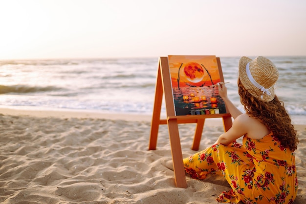 Jovem artista feminina desenhando a imagem na praia Hobby e conceito de lazer