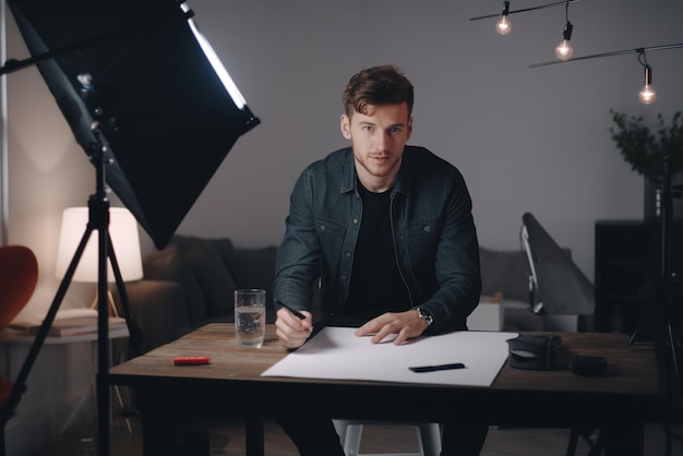 Jovem artista masculino desenhando em sua mesa