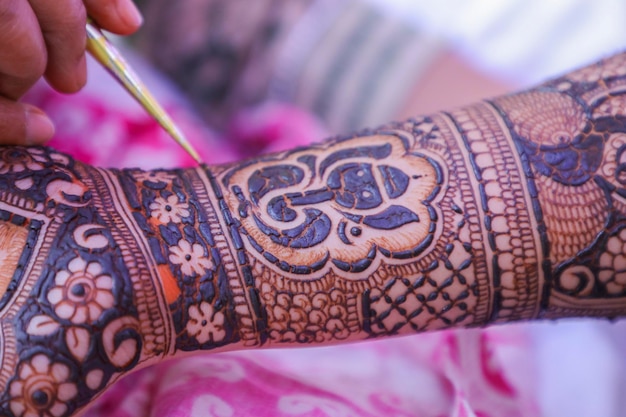 Jovem artista mehendi pintando henna na mão da noiva