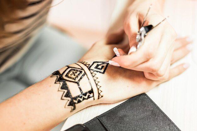 Jovem artista mehendi pintando henna na mão