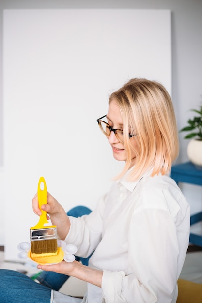 Jovem artista pintando em casa em um estúdio criativo