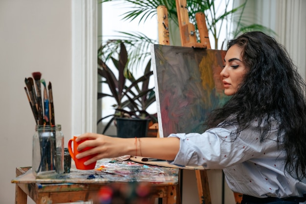Jovem artista trabalhando em uma pintura no estúdio