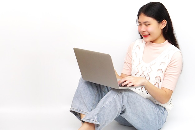 Jovem asiática alegre sentada e usando tecnologia de laptop e conceito de aprendizado