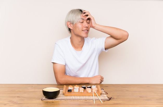 Jovem asiática com sushi em uma mesa rindo