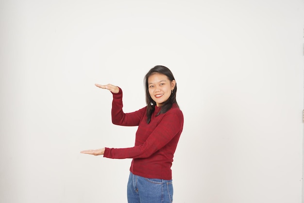 Foto jovem asiática de camisa vermelha medindo e segurando grande produto isolado em fundo branco