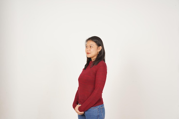 Jovem asiática de camisa vermelha olhando de lado e sorrindo isolada em fundo branco