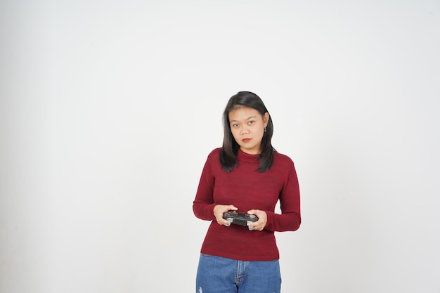 Foto jovem asiática de camisa vermelha segurando um controlador de jogo jogando um jogo isolado em fundo branco