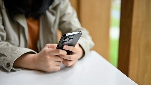 Jovem asiática digitando em seu telefone conversando ou enviando mensagens para seus amigos