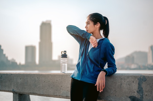Jovem asiática enxuga o suor após um treino matinal na cidade Uma cidade que vive saudável