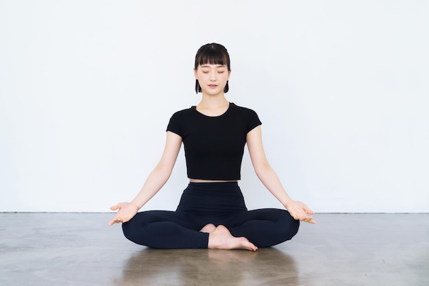 Jovem asiática fazendo meditação mantra em pose de ioga