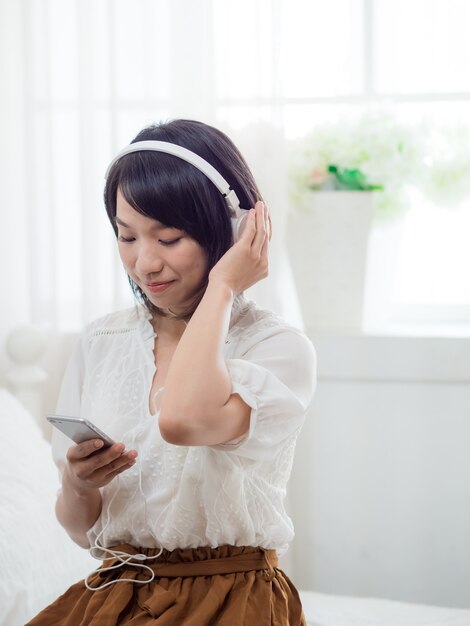 Jovem asiática ouvindo música em casa