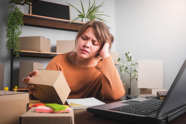 Jovem asiática se sentindo estressada ou deprimida na frente de seu conceito de venda on-line de laptop