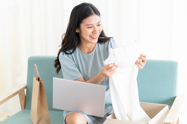 Jovem asiática sentada em casa vendendo online