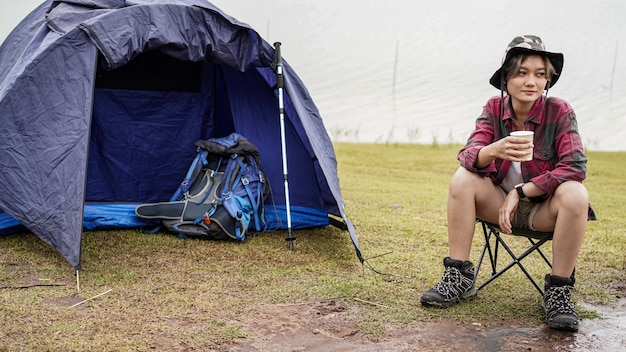 Jovem asiática tomando café na cadeira