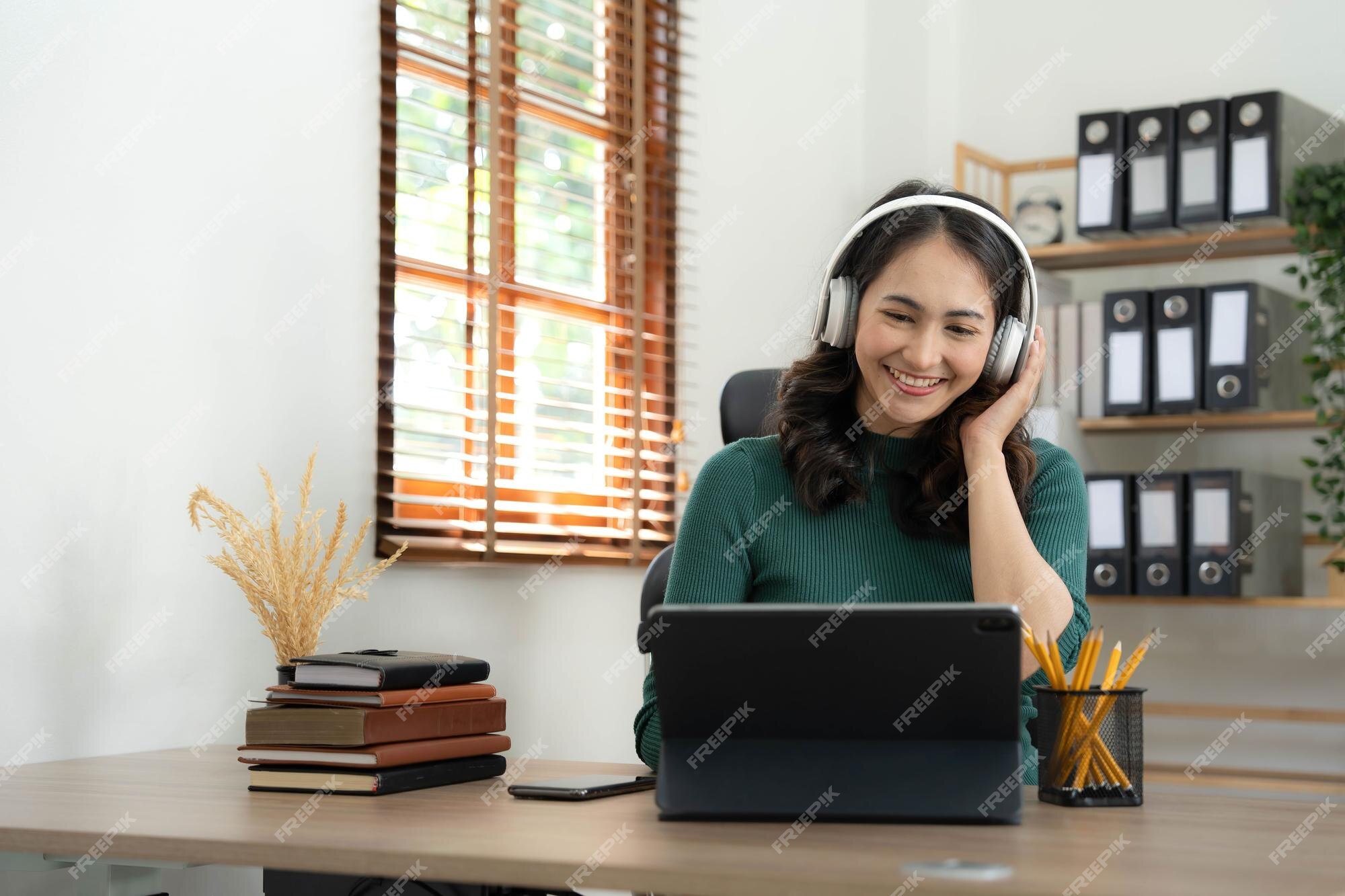 Linda garota asiática usando fone de ouvido aprendendo música de