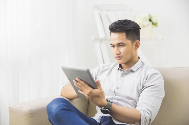 Jovem asiática usando o tablet pc em casa