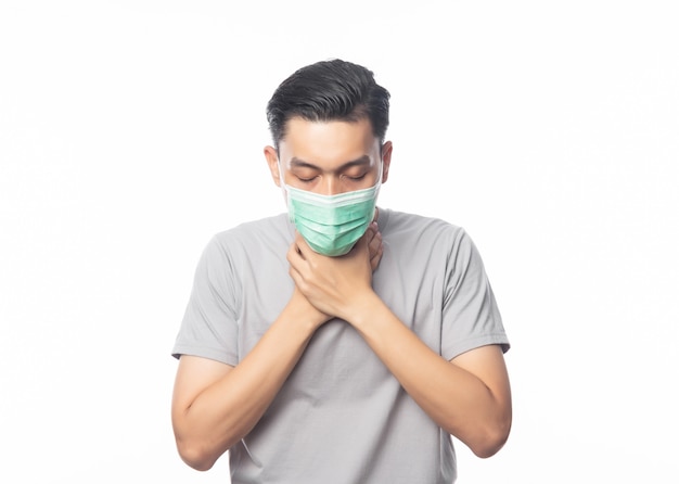 Jovem asiático com máscara higiênica que sofre de dor de garganta, 2019-nCoV ou coronavírus. Doenças respiratórias transportadas por via aérea, como pm 2.5 combate e gripe.