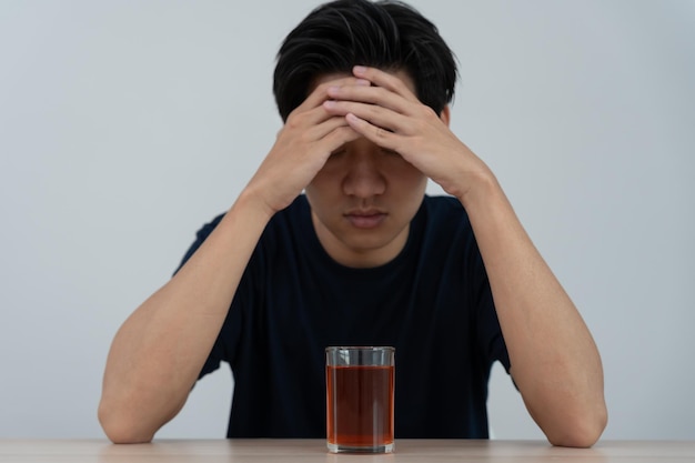 Jovem asiático deprimido viciado sentindo-se mal bebendo uísque sozinho em casa estressado frustrado sozinho bebendo álcool sofre de problemas de alcoolismo vida e problemas familiares