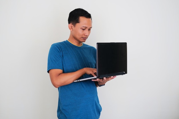 Foto jovem asiático digitando no laptop trabalhando em casa conceito casual