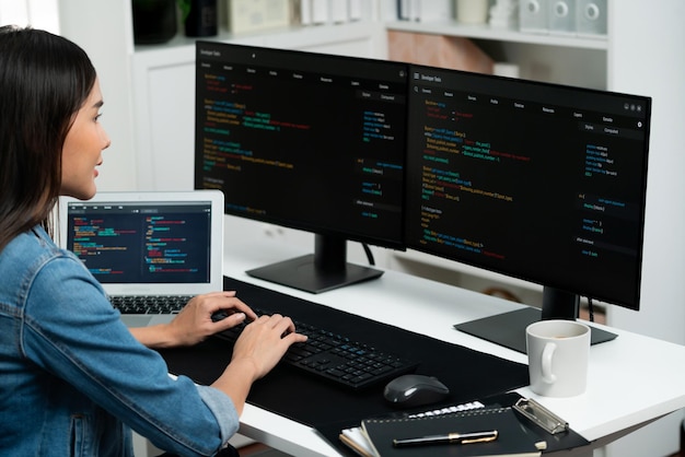 Jovem asiático em TI criando com digitação de informações on-line no PC Stratagem