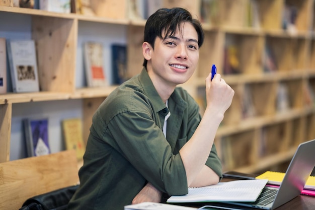 Jovem asiático estudando na biblioteca