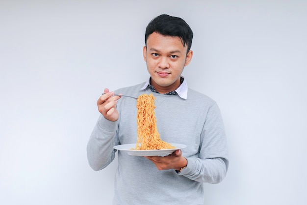 Jovem asiático gosta de macarrão comendo o conceito de almoço