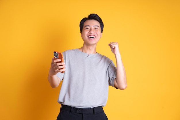 Jovem asiático posando em um fundo amarelo