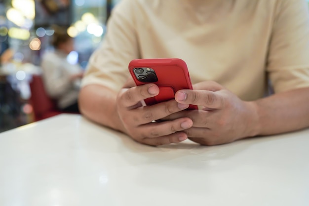 Jovem asiático relaxado usando smartphone passando o tempo verificando notícias mídias sociais