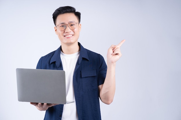 Jovem asiático usando laptop em fundo branco