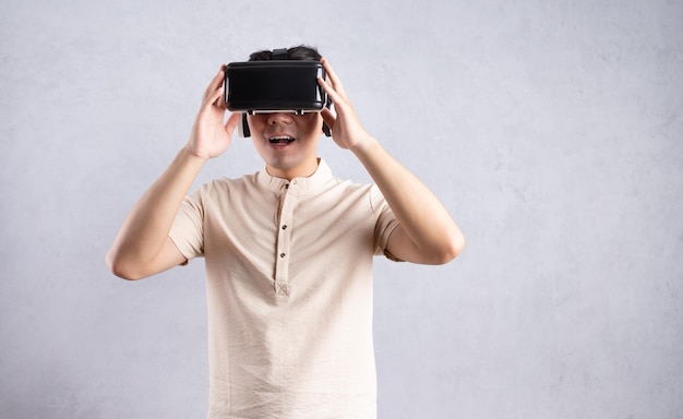 Jovem asiático usando óculos vr no fundo