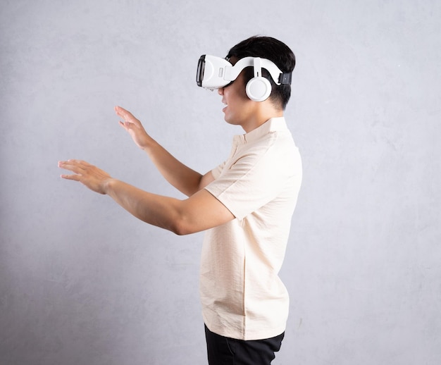 Jovem asiático usando óculos VR no fundo