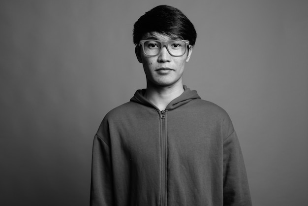 Jovem asiático vestindo jaqueta com óculos