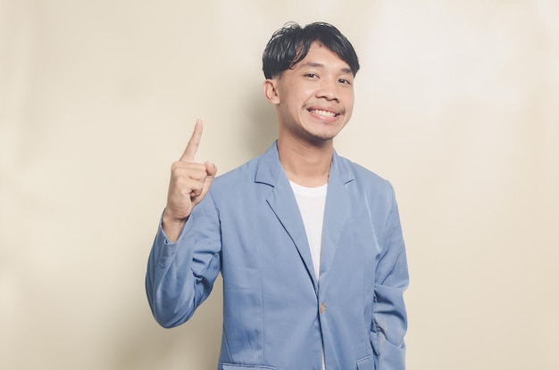 Jovem asiático vestindo terno de faculdade com expressão encontrando ideias em fundo isolado